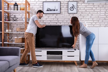 Young Couple Lifting Television
