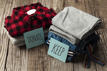 Stack of old clothes to discard (declutter) or keep. Recycle clothes, eco cotton, apartment moving