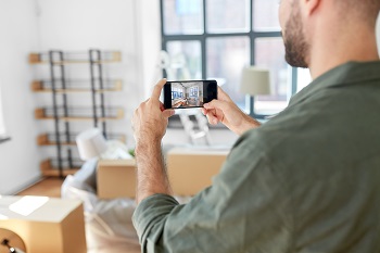 man with smartphone taking picture of new home, apartment moving